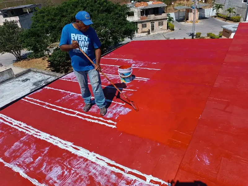 Trabajador de JUMENCO aplicando recubrimiento en una cubierta en Maracay